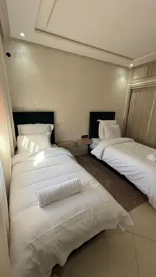 two beds in a room with white sheets at Abir37 in Marrakech