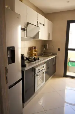 a kitchen with stainless steel appliances and white cabinets at Abir37 in Marrakech