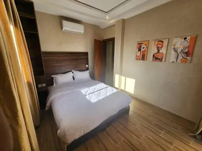 a bedroom with a large bed in a room at Appartement Aéroport Holiday in Marrakech