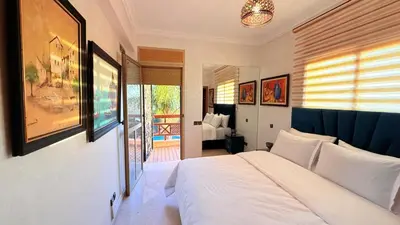 a bedroom with a white bed and a balcony at HiverLux in Marrakech