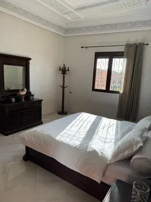 a bedroom with a large bed with a cross on it at Maison luxueuse méga spacieuse in Marrakech