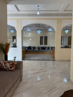 a large room with a couch in the middle at Maison luxueuse méga spacieuse in Marrakech