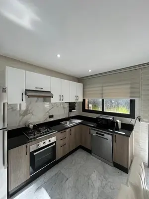 a kitchen with stainless steel appliances and white cabinets at Spacieux duplex 3 chambres - Piscine et parking in Marrakech