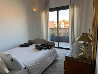 a bedroom with a bed and a large window at Exceptional duplex apartment in Guéliz with Jacuzzi in Marrakech