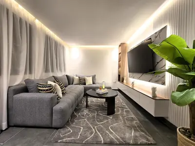 a living room with a couch and a tv at Central New 1BR Next to the Train Station in Marrakech