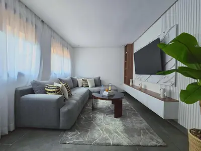 a living room with a couch and a tv at Central New 1BR Next to the Train Station in Marrakech