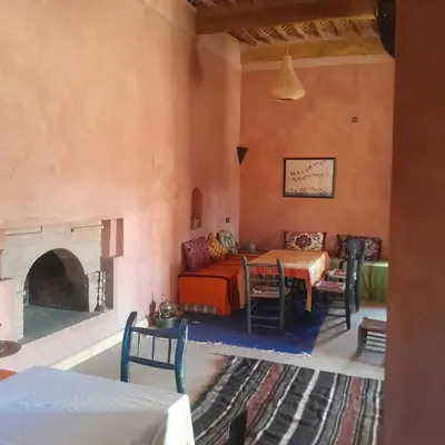 a room with a couch and a table and a fireplace at Chants des dunes in Marrakech