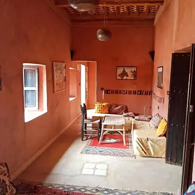 a living room with a table and a couch at Chants des dunes in Marrakech