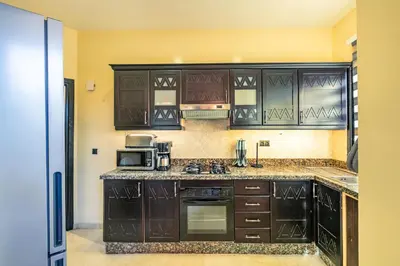 a kitchen with black cabinets and a microwave at Nid Andalou balcony and calm in Oulad Akkou