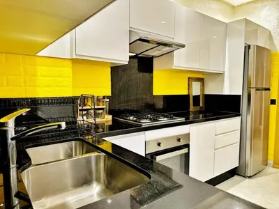 a kitchen with white cabinets and a stainless steel sink at Appartement Marrakech-GOLDEN OASIS in Marrakech
