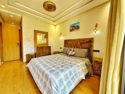 a bedroom with a large bed with a blue blanket at Appartement Marrakech-GOLDEN OASIS in Marrakech