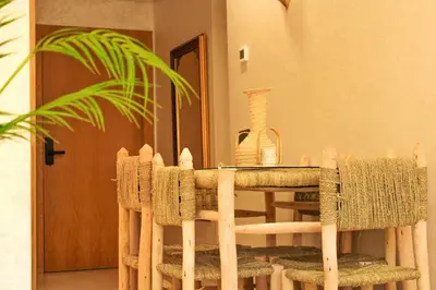a dining room table with chairs and a plant at Appartement Marrakech-GOLDEN OASIS in Marrakech