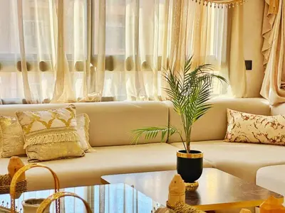 a living room with a couch and a potted plant at Appartement Marrakech-GOLDEN OASIS in Marrakech