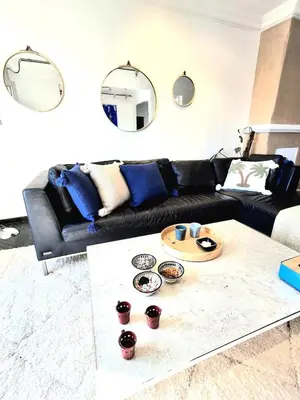 a living room with a black couch and a table at Central Atlas View in Marrakech
