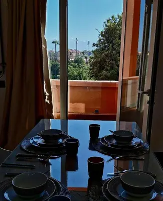 a glass table with bowls and plates on it with a window at Central Atlas View in Marrakech