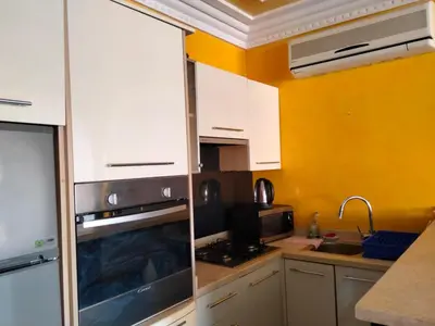 a kitchen with white cabinets and a stove top oven at Babylon 1