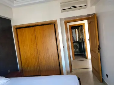 a room with a bed and a wooden door and a hallway at Babylon 1