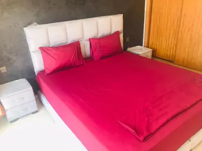 a bed with red sheets and red pillows at Babylon 1