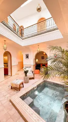 an indoor swimming pool in a large room with a ceiling at Private - Riad Désiré Marrakech in Marrakech