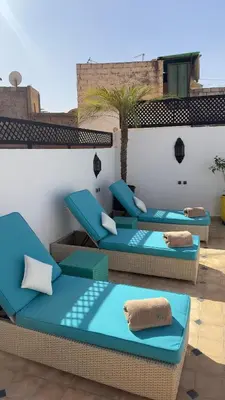 a patio with blue cushioned chairs on a roof at Private - Riad Désiré Marrakech in Marrakech
