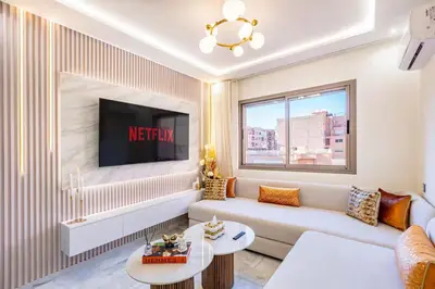a living room with a couch and a tv at Studio chic Guéliz à deux pas de Carré Eden Avec Parking in Marrakech