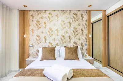 a bedroom with a large white bed and a wall at Studio chic Guéliz à deux pas de Carré Eden Avec Parking in Marrakech