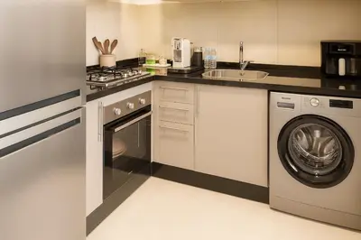 a kitchen with a washing machine and a sink at Sophisticated & Cozy Home in Vibrant Marrakech in Marrakech