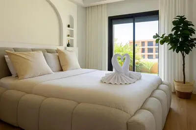 a bedroom with a bed with a swan decoration on it at 2 chambres avec terrasse vue piscine in Marrakech