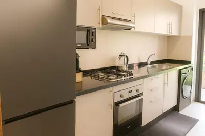 a kitchen with white cabinets and a stove top oven at 2 chambres avec terrasse vue piscine in Marrakech