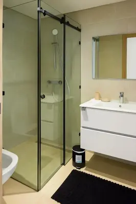 a bathroom with a glass shower and a sink at 2 chambres avec terrasse vue piscine in Marrakech