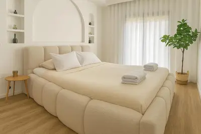 a white bedroom with a large bed with towels on it at 2 chambres avec terrasse vue piscine in Marrakech
