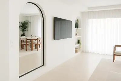 a mirror in a white room with a table at 2 chambres avec terrasse vue piscine in Marrakech