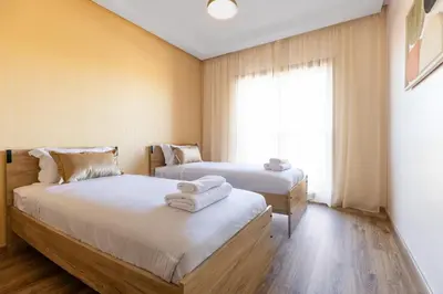 two beds in a room with a window at Atlas Luxury Escape Golf Noria Pool & Quiet in Marrakech