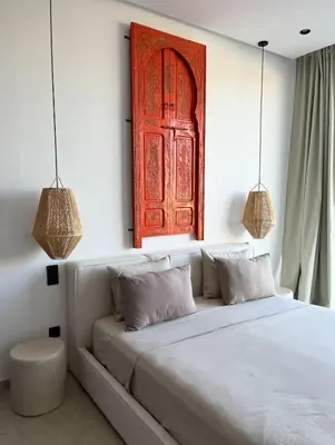 a bedroom with a bed with a red door at Villa Marraktus Marrakech in Marrakech