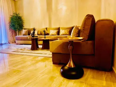 a living room with a couch and a table at Appartement de luxe avec piscine in Marrakech