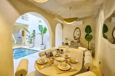 a dining room with a table and chairs and a pool at Luxury Private Riad - Pool - Breakfast Included in Marrakech