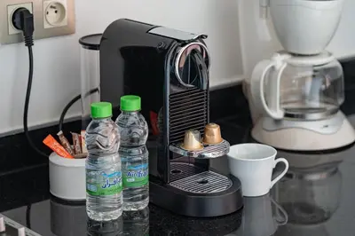 a coffee maker and two bottles of water on a counter at Charming apartment in the center of Victor Hugo Gueliz in Marrakech