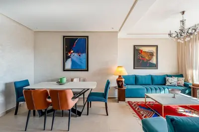 a living room with a blue couch and a table at Charming apartment in the center of Victor Hugo Gueliz in Marrakech