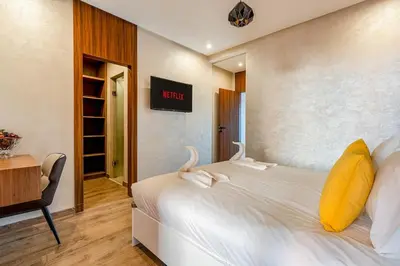 a bedroom with a bed with a yellow pillow and a desk at Charming apartment in the center of Victor Hugo Gueliz in Marrakech
