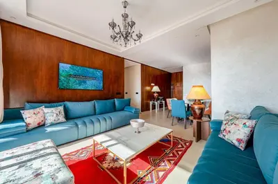 a living room with a blue couch and a table at Charming apartment in the center of Victor Hugo Gueliz in Marrakech