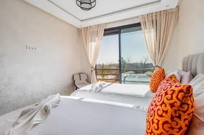 two beds in a hotel room with a window at Charming apartment in the center of Victor Hugo Gueliz in Marrakech