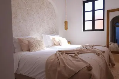 a bedroom with two beds with white sheets and a window at Little date in Marrakech