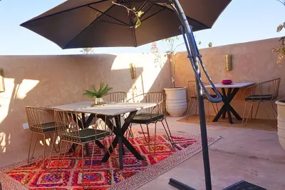 a table and chairs with an umbrella on a patio at Little date in Marrakech