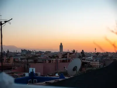 a view of a city at sunset from a rooftop at Riad Jebly - Exclusive -Jacuzzi & Breakfast ,10 min walk Jemaa El Fnaa - Panoramic View Rooftop in Marrakech