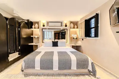 a bedroom with a large bed with black and white stripes at Riad Jebly - Exclusive -Jacuzzi & Breakfast ,10 min walk Jemaa El Fnaa - Panoramic View Rooftop in Marrakech