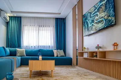 a living room with a blue couch and a table at CAN 2025 - T2 design Gare de Marrakech - Guéliz-Hivernage - WiFi in Marrakech