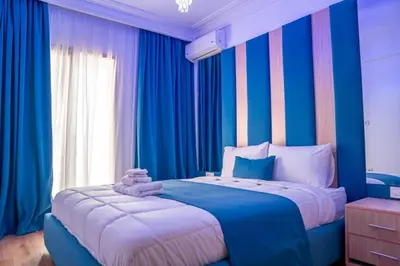 a blue bedroom with a large bed with blue curtains at CAN 2025 - T2 design Gare de Marrakech - Guéliz-Hivernage - WiFi in Marrakech