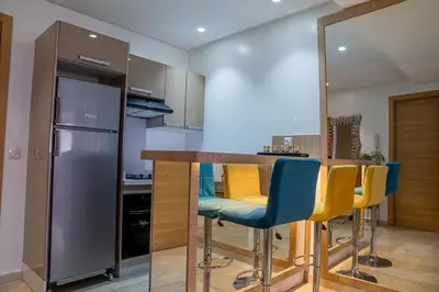 a kitchen with a bar with blue and yellow chairs at CAN 2025 - T2 design Gare de Marrakech - Guéliz-Hivernage - WiFi in Marrakech