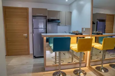 a kitchen with yellow and blue bar stools at CAN 2025 - T2 design Gare de Marrakech - Guéliz-Hivernage - WiFi in Marrakech