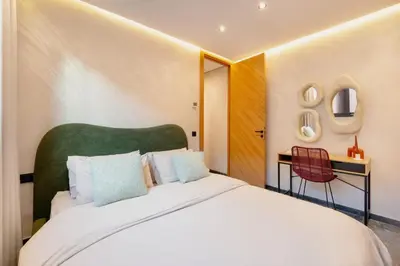 a bedroom with a large white bed with a green headboard at Cocooning escape Relaxation, design and serenity in Marrakech